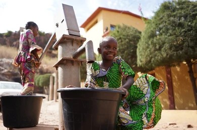 Volunteer teacher helping school kids at their desks